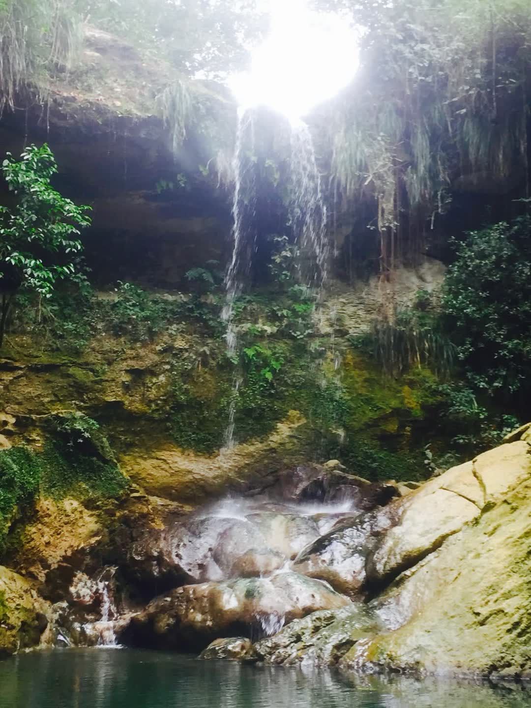 Sunlit waterfall in a jungle canyon