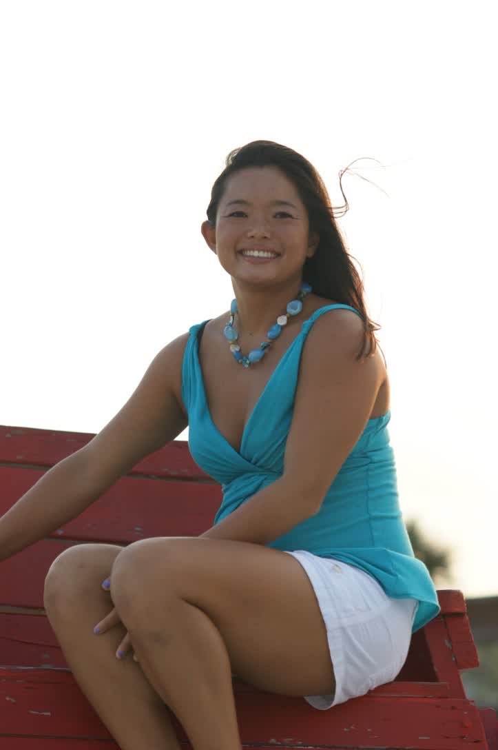 Miriam seated on a red lifeguard stand at the beach